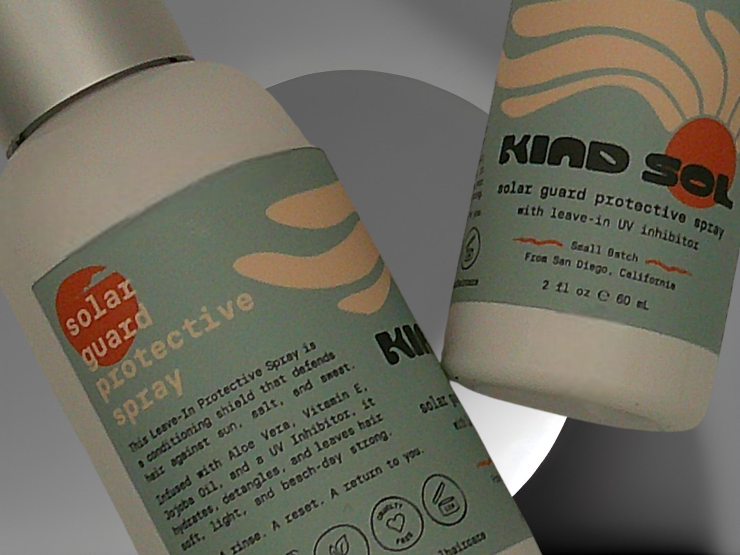 Two bottles of Kind Sol solar guard protective spray on a gray background